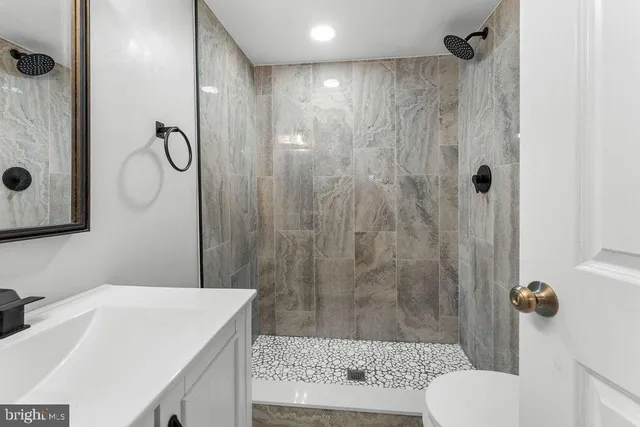 a bathroom with a granite countertop sink toilet and shower