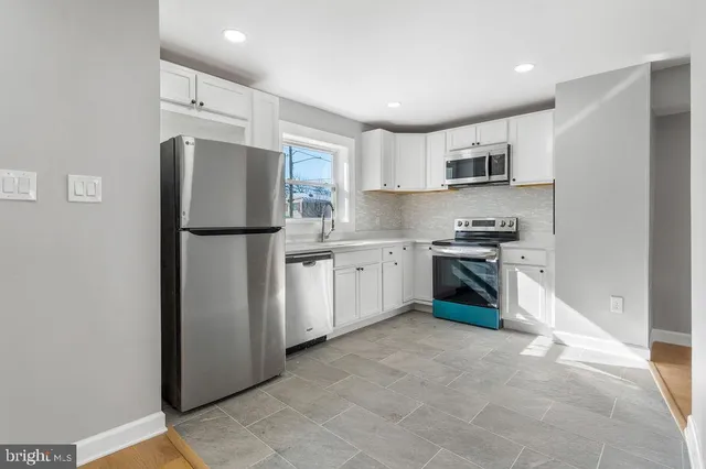 a kitchen with stainless steel appliances a refrigerator sink and cabinets