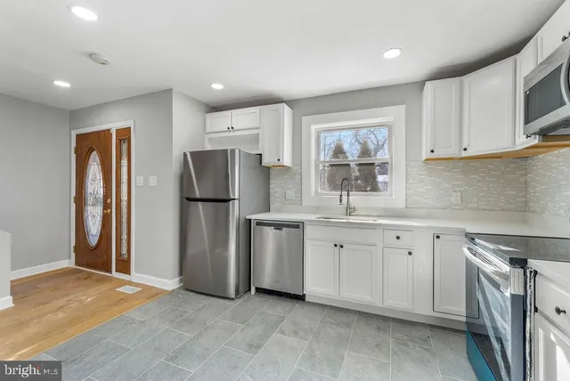 a kitchen with refrigerator cabinets and a sink