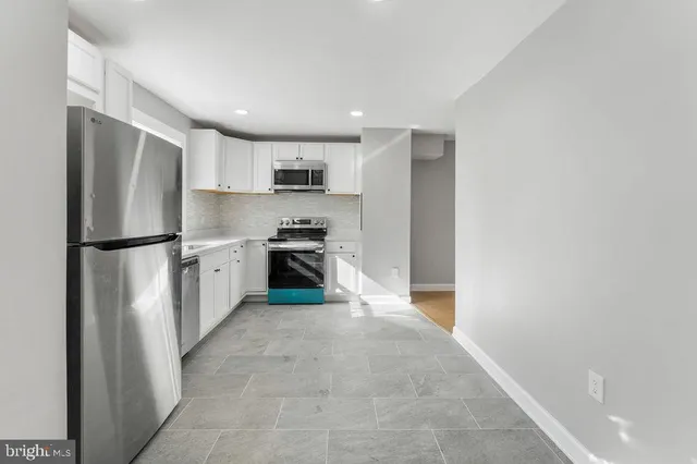 a kitchen with stainless steel appliances a refrigerator and a stove top oven