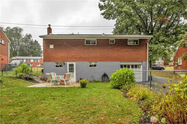 a view of a chair and table in backyard of the house