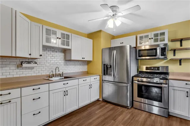 a kitchen with stainless steel appliances granite countertop a refrigerator a stove a sink dishwasher and a microwave oven with cabinets