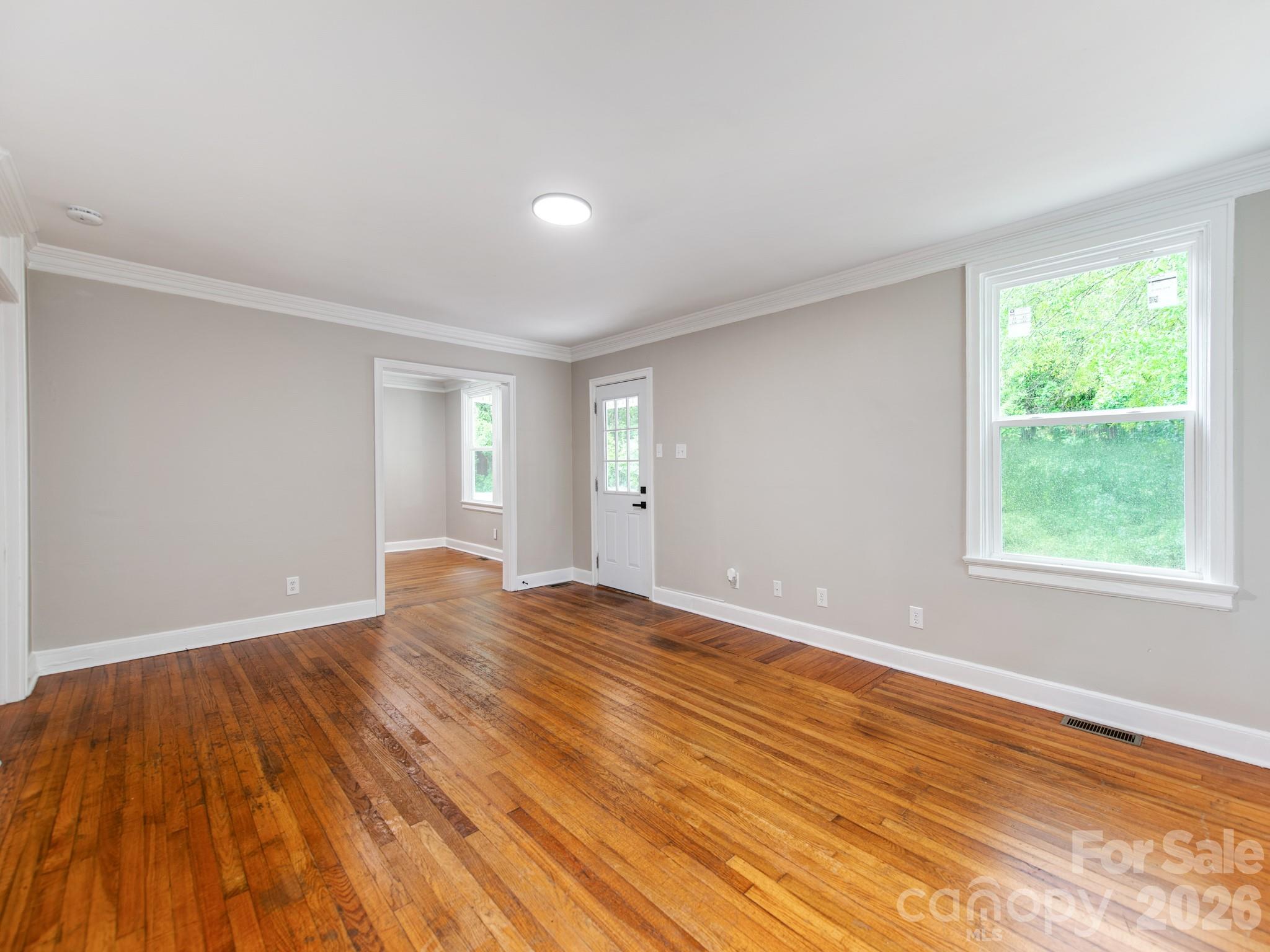 4699 Cherrystone Road Lancaster, SC 29720 - Photo 4 of 28 a view of an empty room with wooden floor and a window