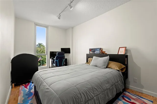 a bedroom with a bed and dresser with chair