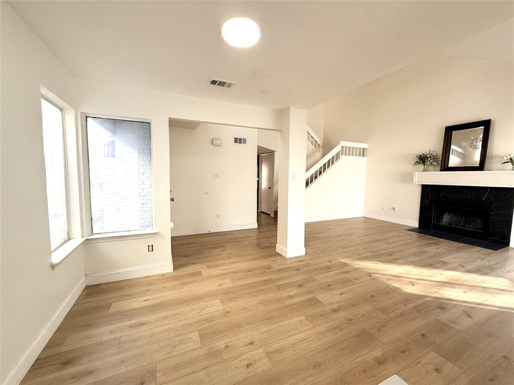 4243 Timberglen Road Dallas, TX 75287 - Photo 15 of 16 a view of empty room with a fireplace and wooden floor
