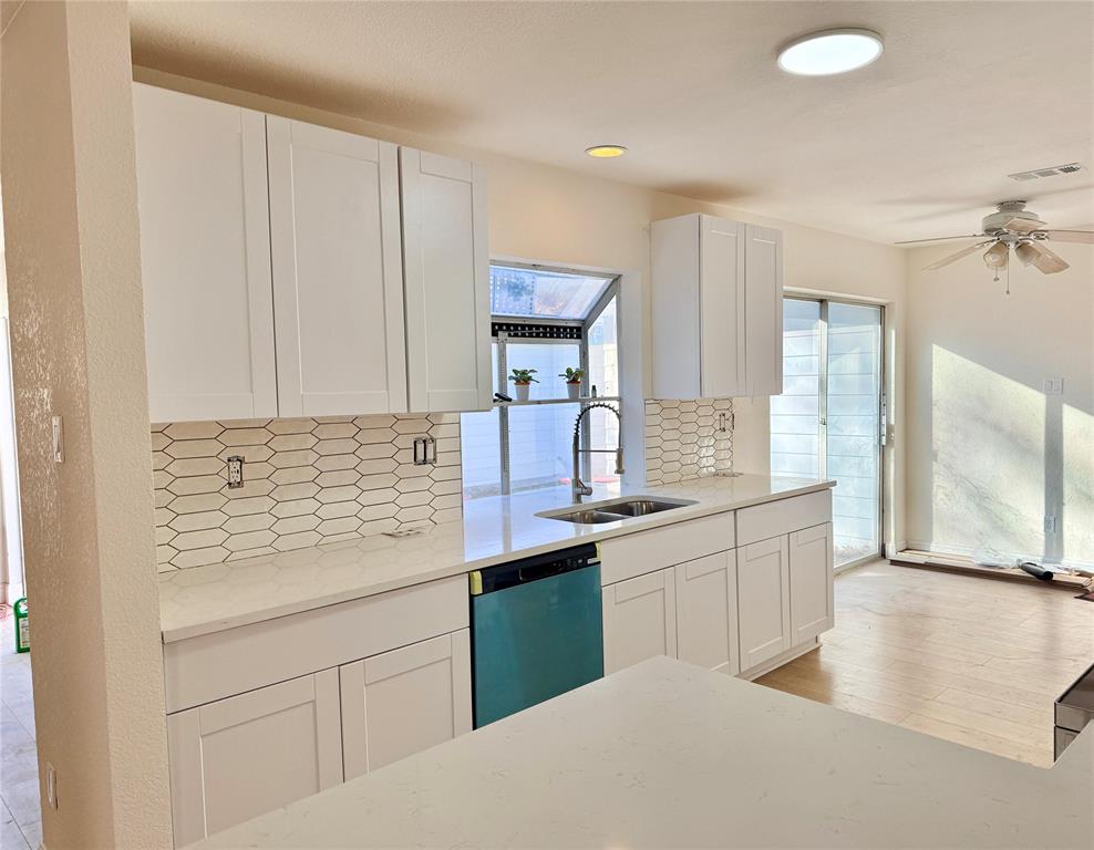 4243 Timberglen Road Dallas, TX 75287 - Photo 2 of 16 a kitchen with granite countertop a sink stainless steel appliances white cabinets and a window