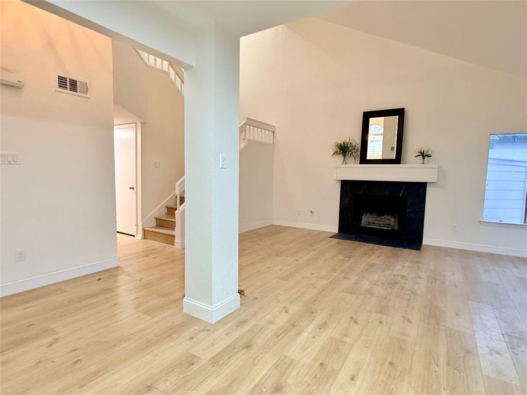 4243 Timberglen Road Dallas, TX 75287 - Photo 6 of 16 a view of empty room with wooden floor and fireplace