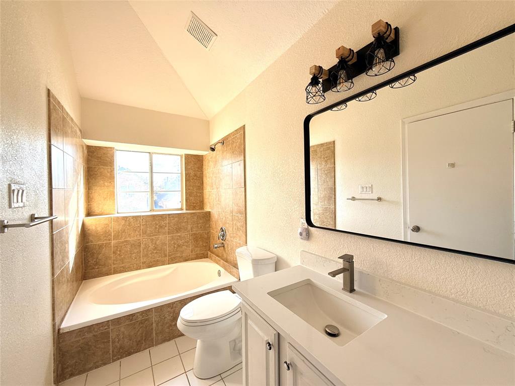 4243 Timberglen Road Dallas, TX 75287 - Photo 8 of 16 a bathroom with a sink a toilet a mirror and bathtub
