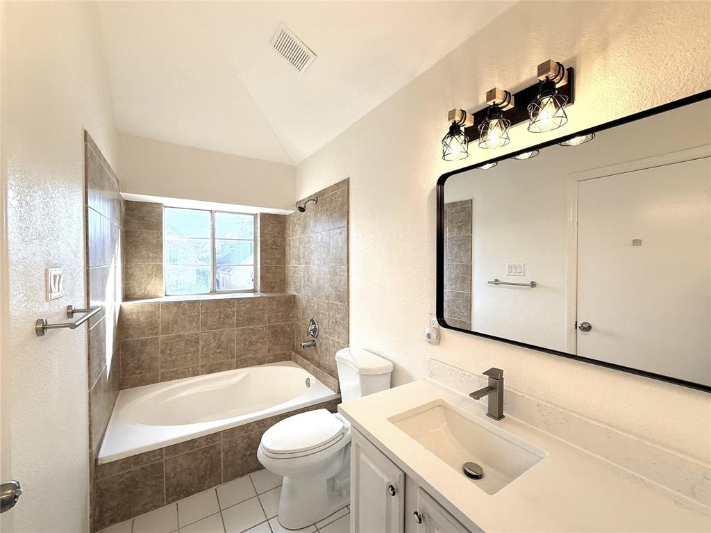 4243 Timberglen Road Dallas, TX 75287 - Photo 9 of 16 a bathroom with a bathtub a sink and a mirror
