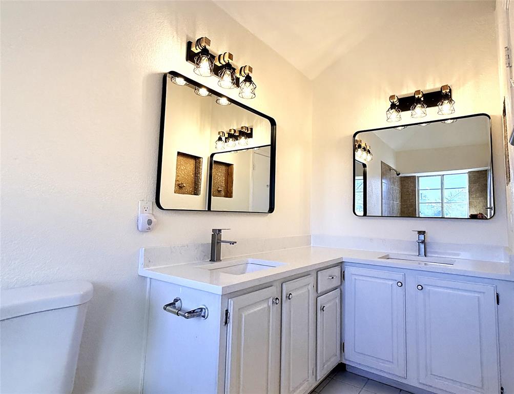 4243 Timberglen Road Dallas, TX 75287 - Photo 10 of 16 a bathroom with 2 sink and a mirror