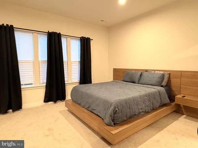 a bed sitting in a bedroom next to a window