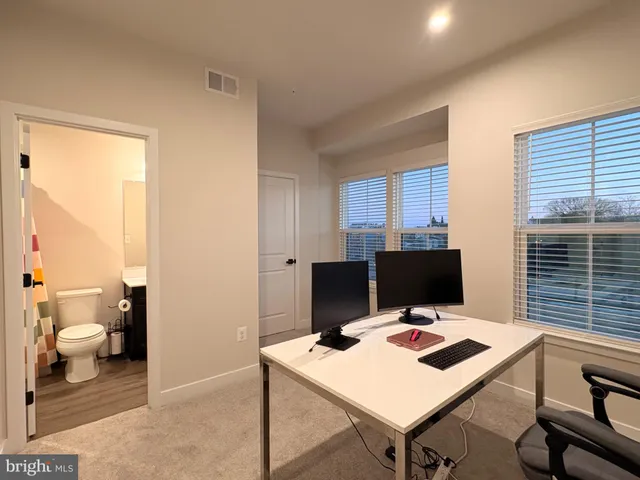 a view of a workspace with furniture and a table