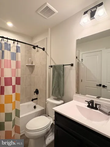 a bathroom with a sink a toilet a mirror and shower