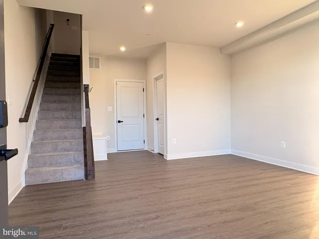 an empty room with wooden floor and staircase