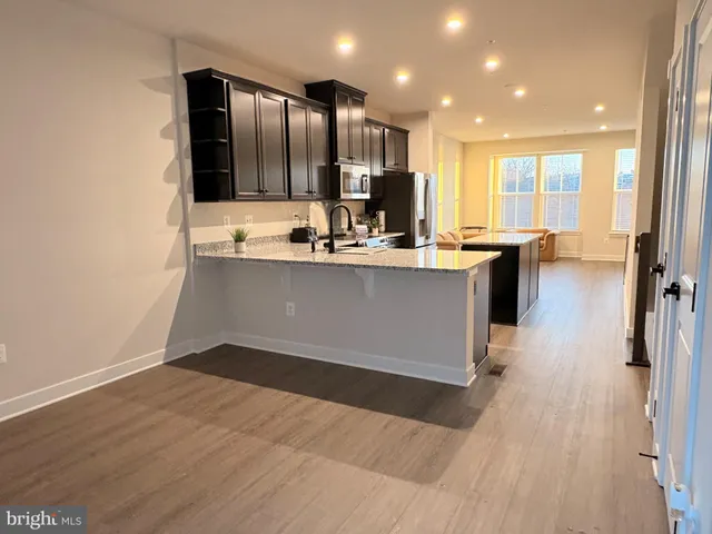 a view of kitchen with stainless steel appliances granite countertop a sink counter top space and cabinets