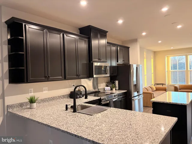 a kitchen with granite countertop a refrigerator and a sink