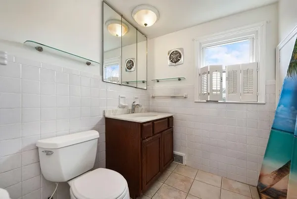 a bathroom with a toilet sink vanity and mirror