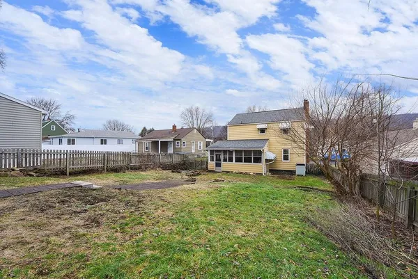 a view of a big house with a big yard and a large tree