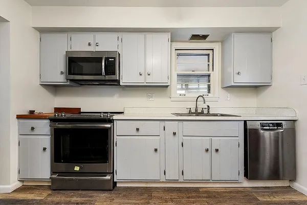 a kitchen with stainless steel appliances granite countertop a stove a microwave and a sink