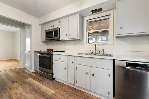 a kitchen with stainless steel appliances white cabinets and a sink