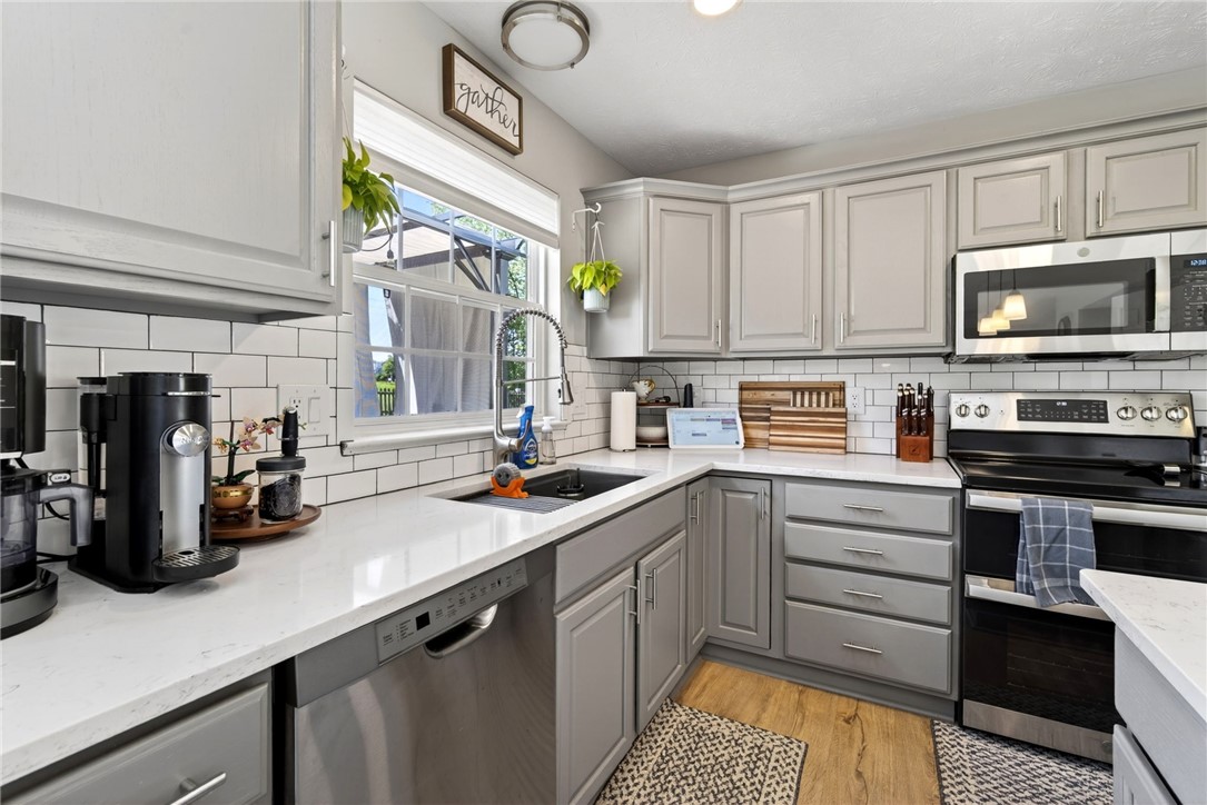 39 Holly Court Springboro, OH 45066 - Photo 12 of 42 This modern kitchen features crisp white countertops and a subway tile backsplash.
