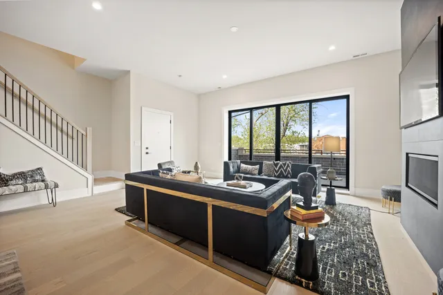 a living room with furniture a rug and a floor to ceiling window