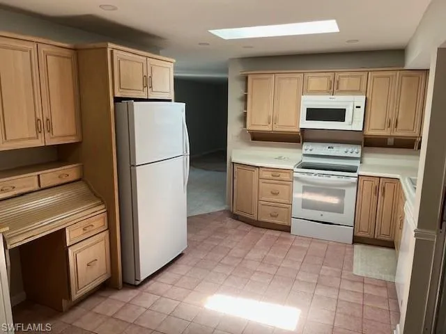 a kitchen with white cabinets and white appliances