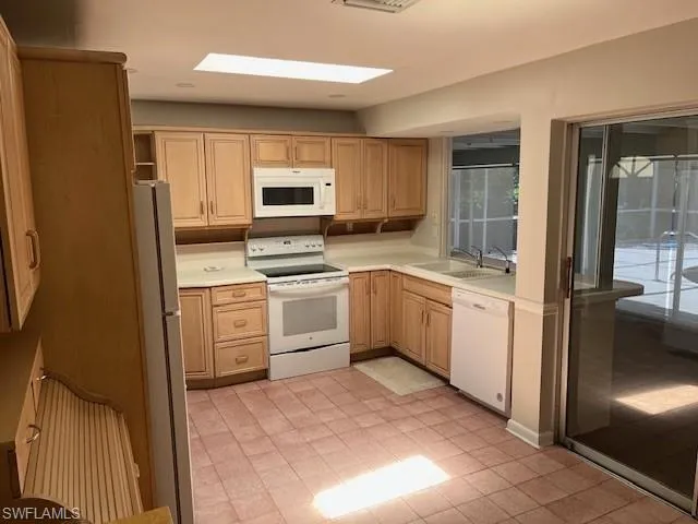 a kitchen with a sink a counter top space stainless steel appliances and cabinets