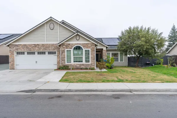 a front view of a house with a garden and garage