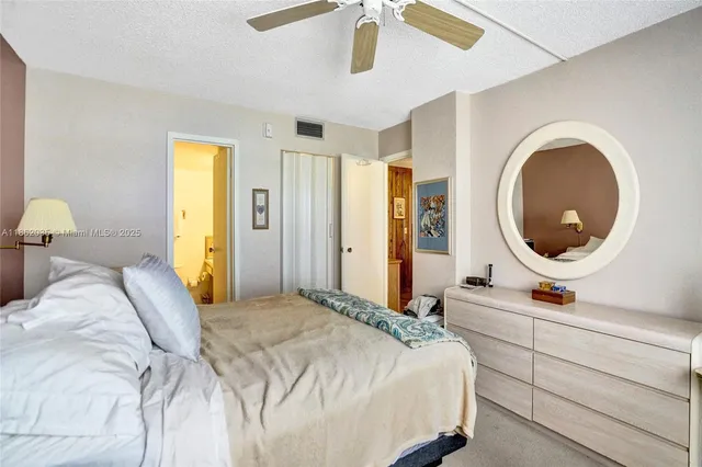 a bedroom with a bed a mirror and lamp