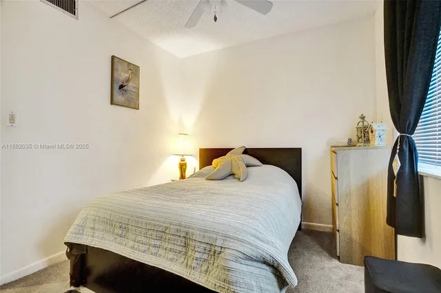 a bedroom with a bed and a flat tv screen on a dresser