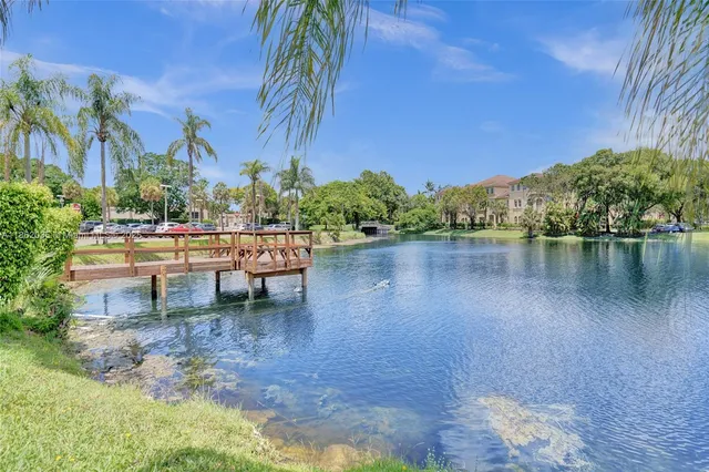 a view of a lake with chairs and table in the patio
