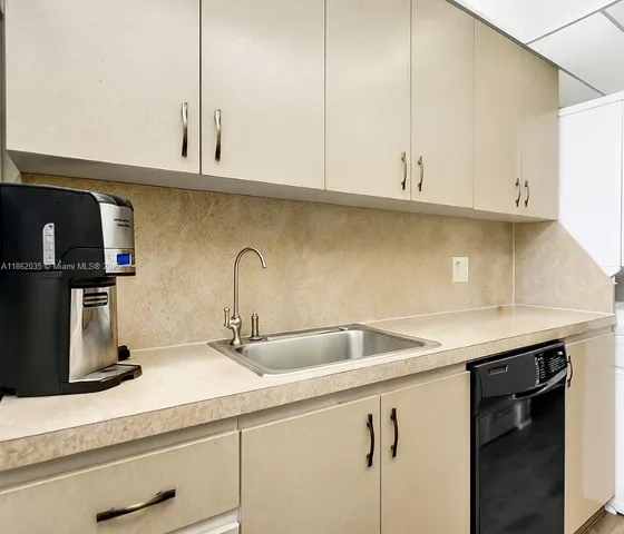 a kitchen with stainless steel appliances granite countertop white cabinets and a sink