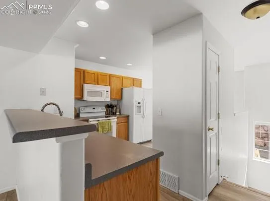 a kitchen with stainless steel appliances granite countertop a refrigerator a sink a stove and island