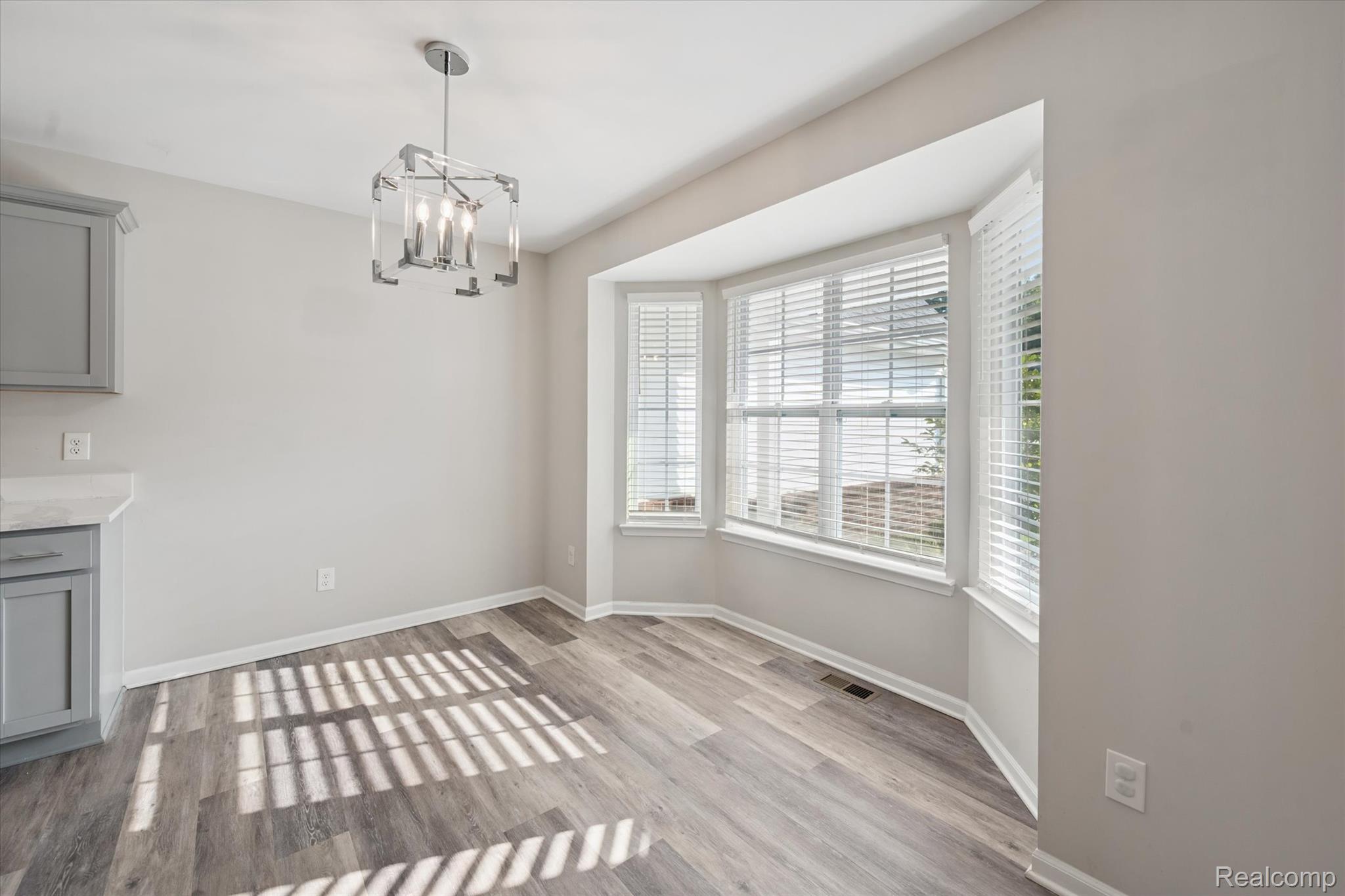 816 Nelson's Ridge Drive Howell, MI 48843 - Photo 12 of 36 Sun-filled dining area with bay window and contemporary light fixture.
