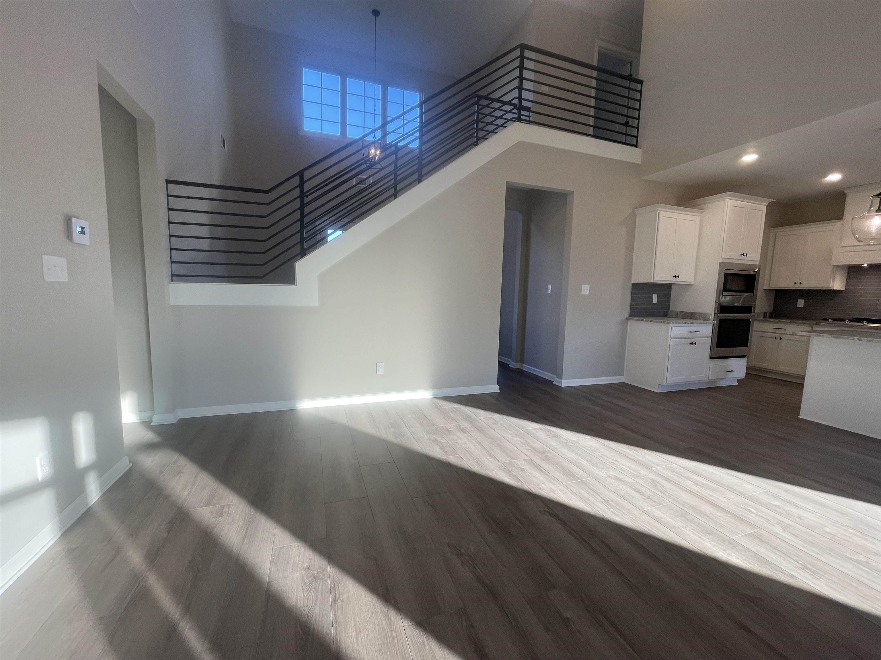 19 Columbia Way Atoka, TN 38004 - Photo 11 of 28 Unfurnished living room with a high ceiling, dark wood-style floors, and recessed lighting