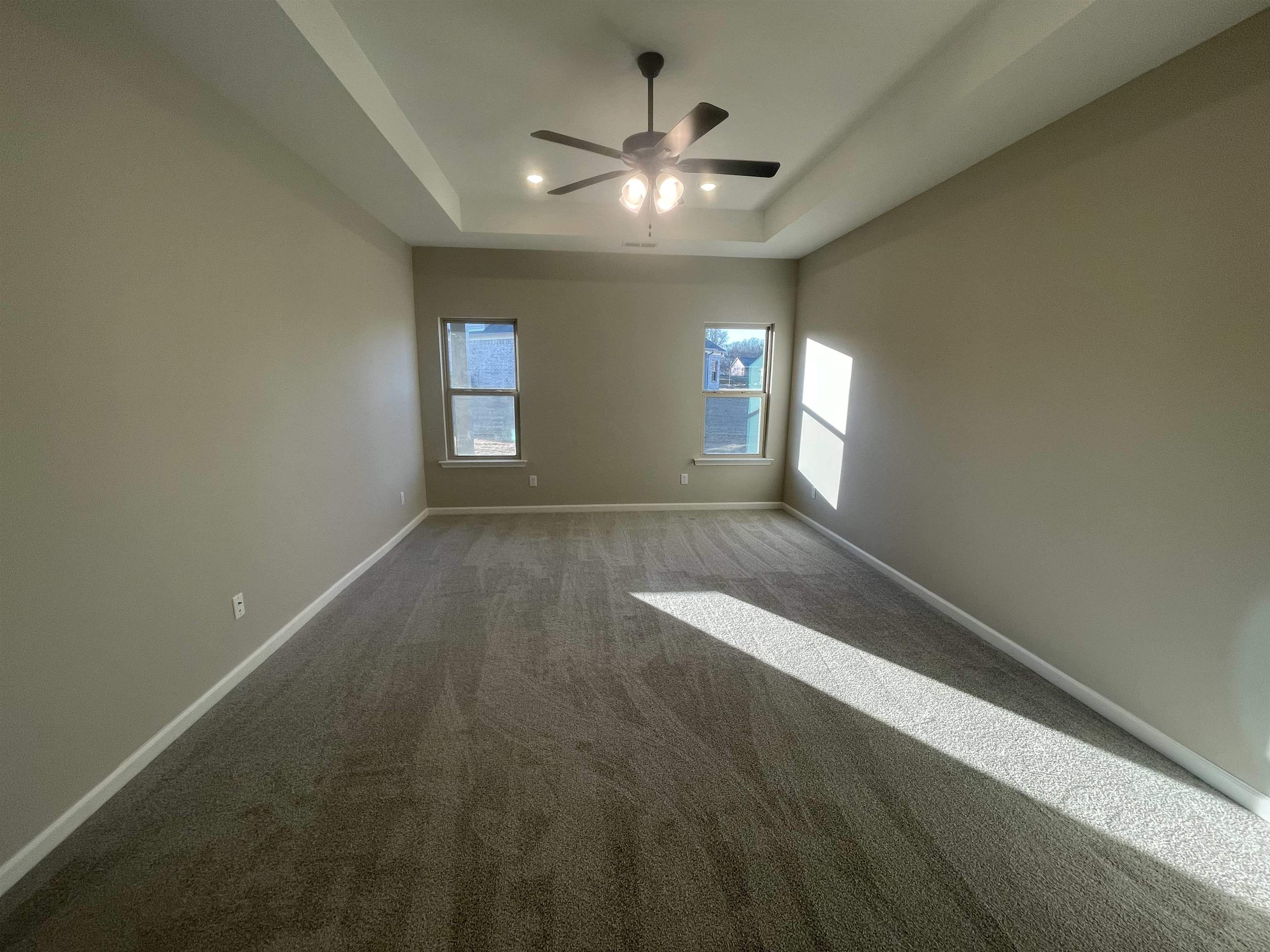 19 Columbia Way Atoka, TN 38004 - Photo 12 of 28 Spare room featuring a raised ceiling, a ceiling fan, and carpet flooring