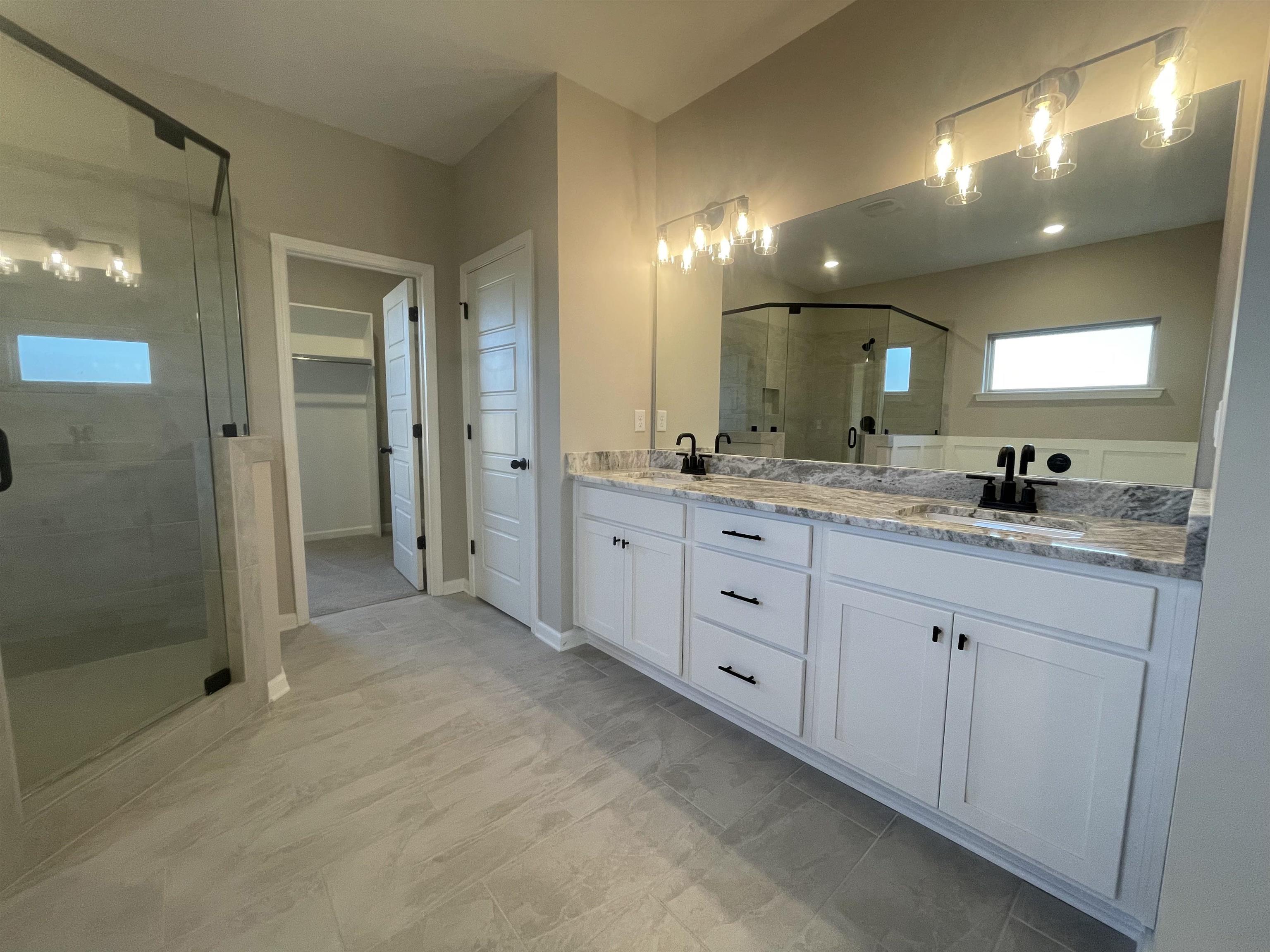 19 Columbia Way Atoka, TN 38004 - Photo 15 of 28 Full bathroom with a stall shower, double vanity, and a spacious closet