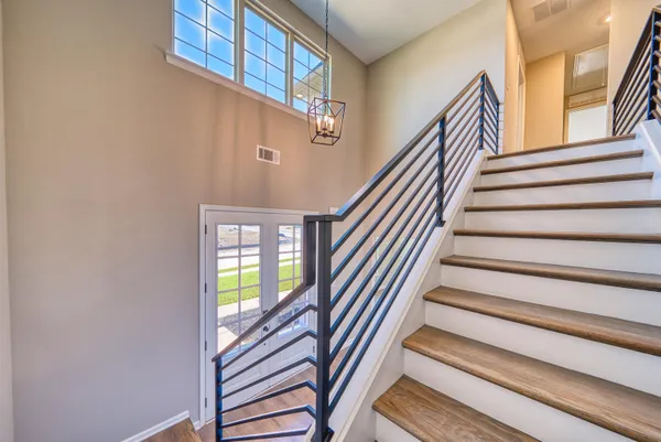 an empty room with wooden floor fireplace and windows