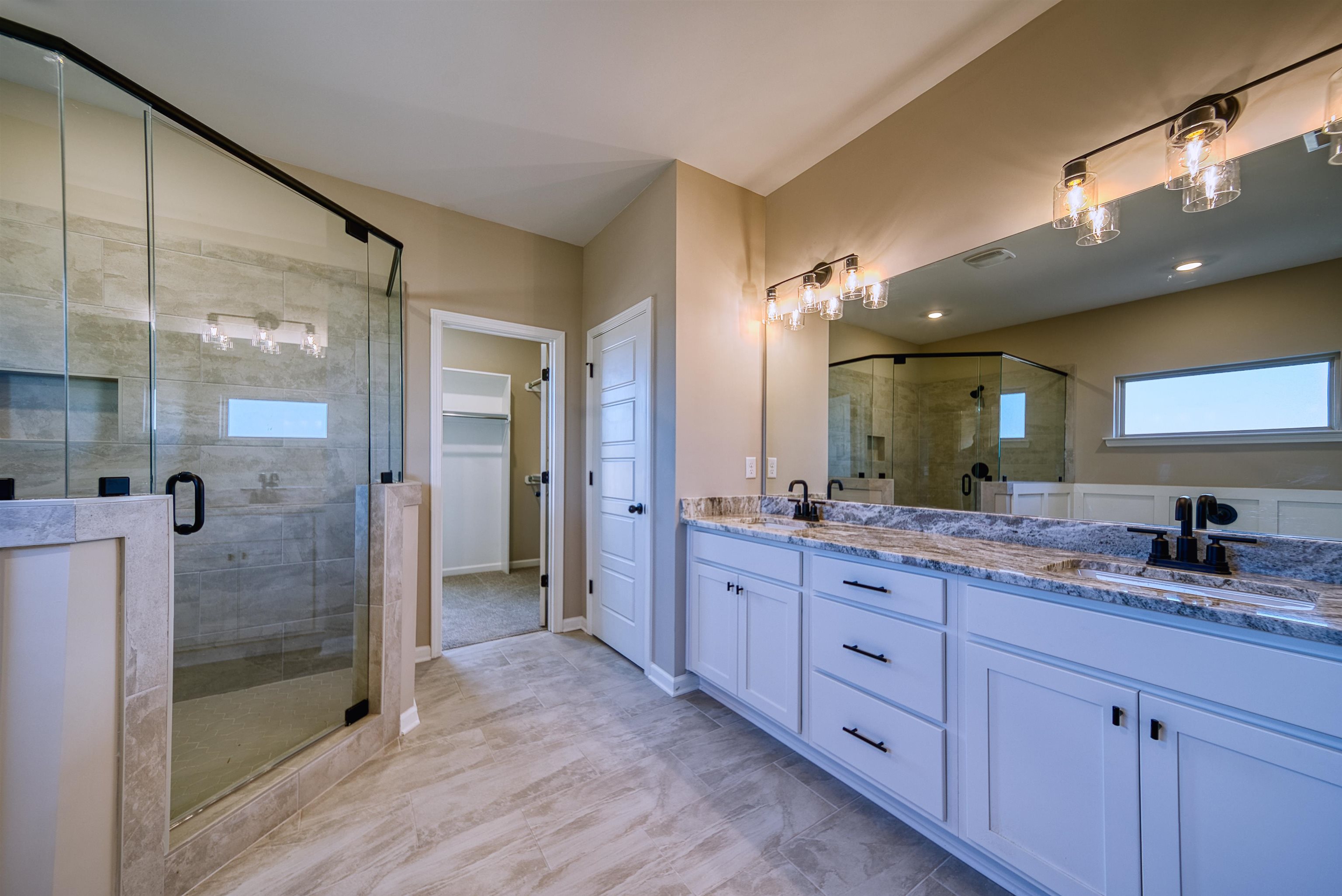 19 Columbia Way Atoka, TN 38004 - Photo 18 of 40 Full bathroom featuring double vanity, a shower stall, and a walk in closet