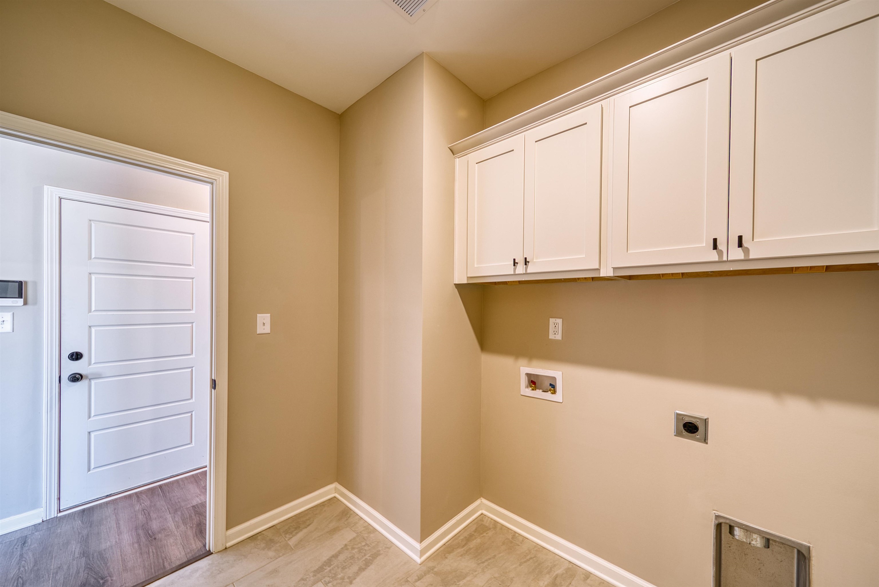 19 Columbia Way Atoka, TN 38004 - Photo 21 of 40 Laundry room with washer hookup, electric dryer hookup, cabinet space, and light wood-style flooring