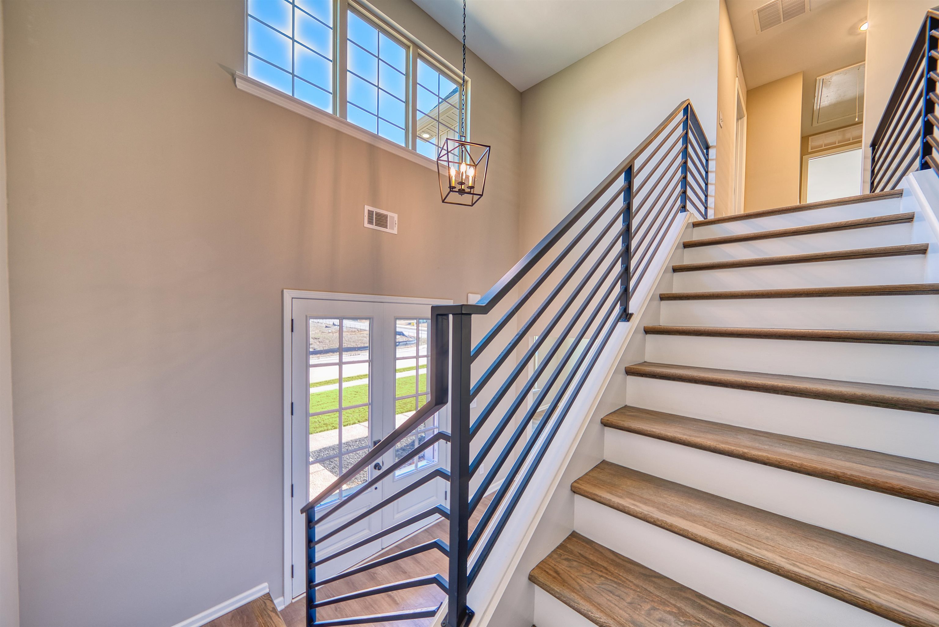 19 Columbia Way Atoka, TN 38004 - Photo 24 of 40 Stairs featuring healthy amount of natural light, hanging lights, wood finished floors, and a high ceiling