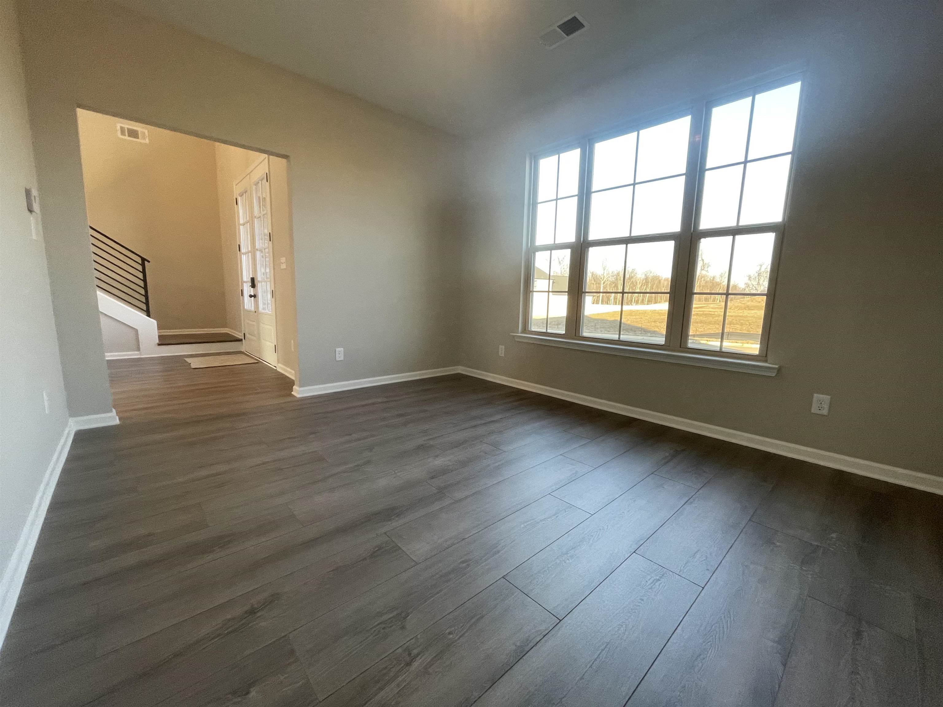 19 Columbia Way Atoka, TN 38004 - Photo 27 of 28 Empty room featuring stairway and dark wood-style floors