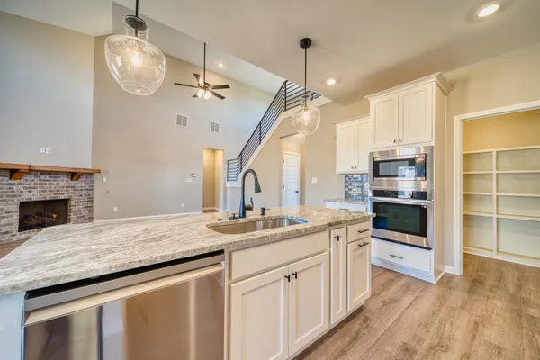 a kitchen with granite countertop a stove and a wooden floor