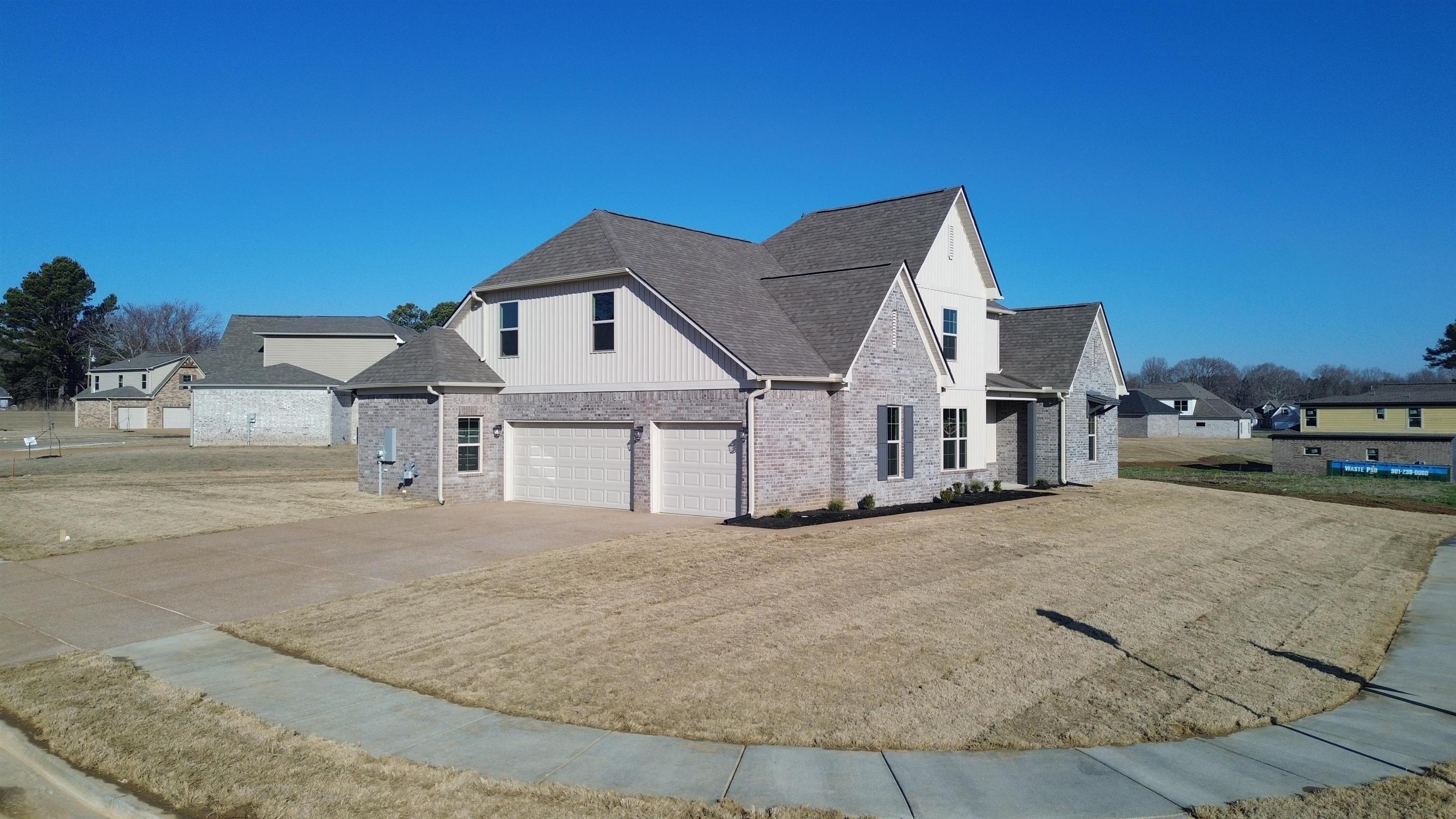 19 Columbia Way Atoka, TN 38004 - Photo 6 of 28 View of front of house with asphalt driveway, a garage, a shingled roof, brick siding, and a front lawn