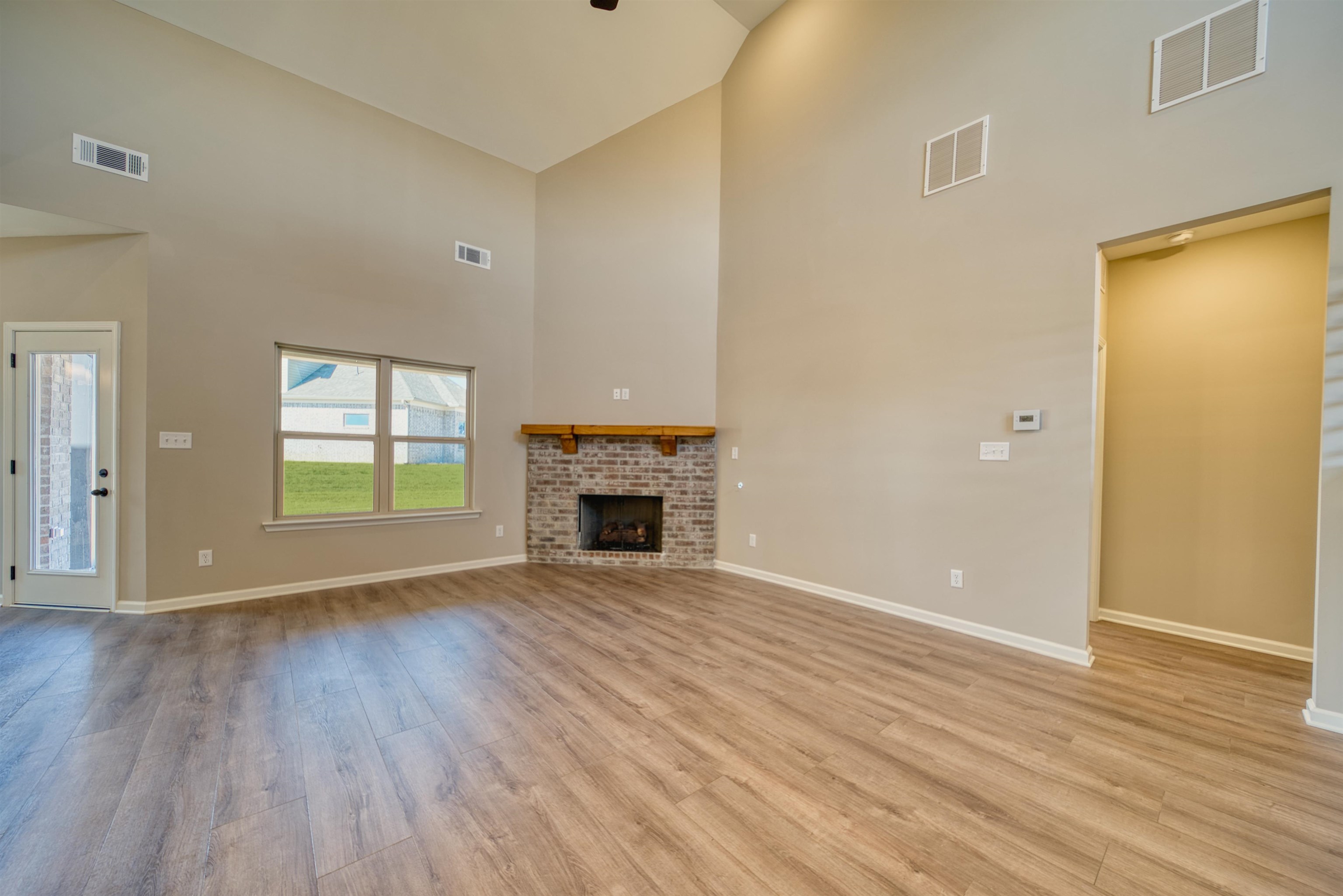 19 Columbia Way Atoka, TN 38004 - Photo 7 of 40 Unfurnished living room with lofted ceiling, a fireplace, light wood finished floors, and ceiling fan