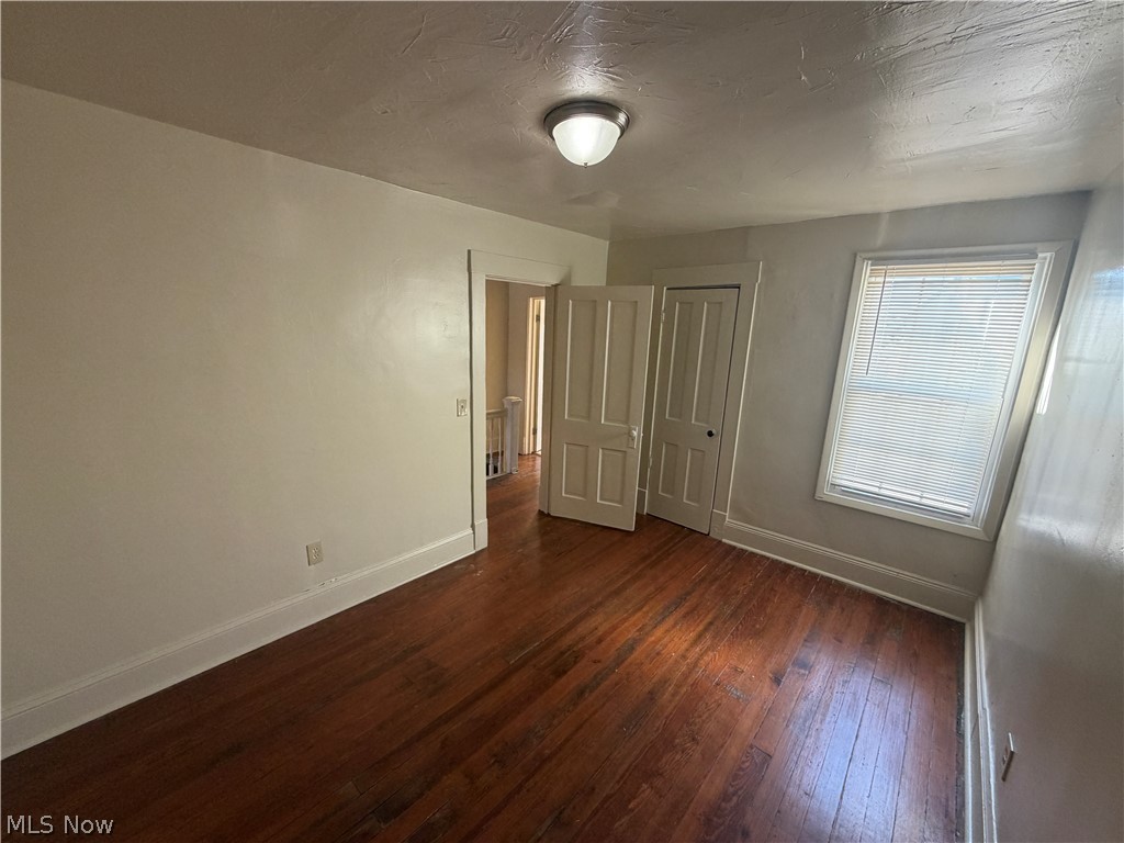 15416 Waterloo Road Cleveland, OH 44110 - Photo 12 of 18 Hardwood flooring throughout featuring white trim and baseboards
