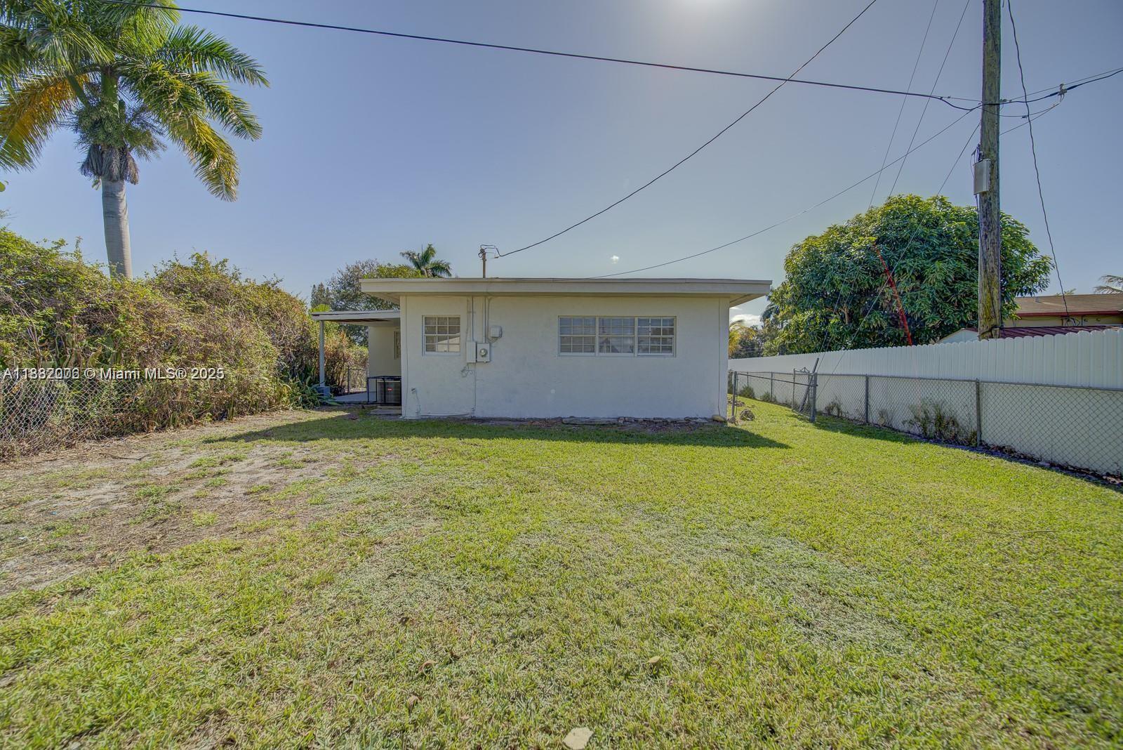 1471 Northwest 93rd Street Miami, FL 33147 - Photo 21 of 26 a front view of house with yard and trees around