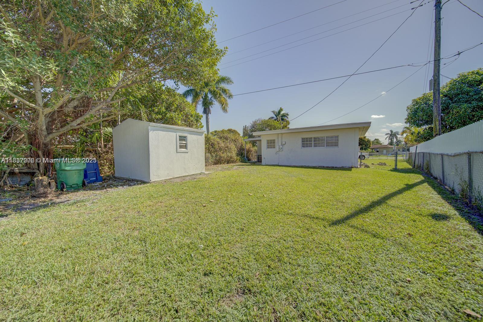 1471 Northwest 93rd Street Miami, FL 33147 - Photo 10 of 26 a view of a yard with a house and a large tree