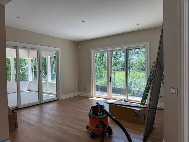 a view of an empty room with wooden floor and a floor to ceiling window